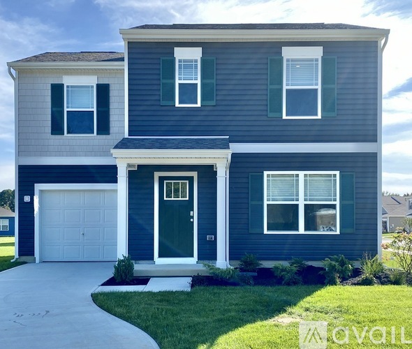 A two-story house with a garage on the first floor and a front door with a small porch.