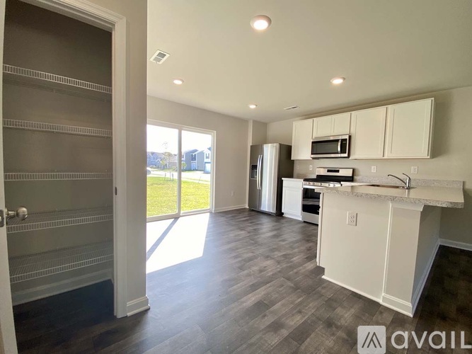 A kitchen with white cabinets and a countertop is available for rent.