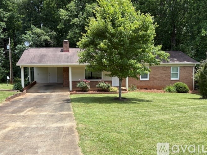 A house with a white porch and a tree in front.