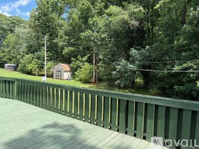 A wooden bridge with a green railing over a river.