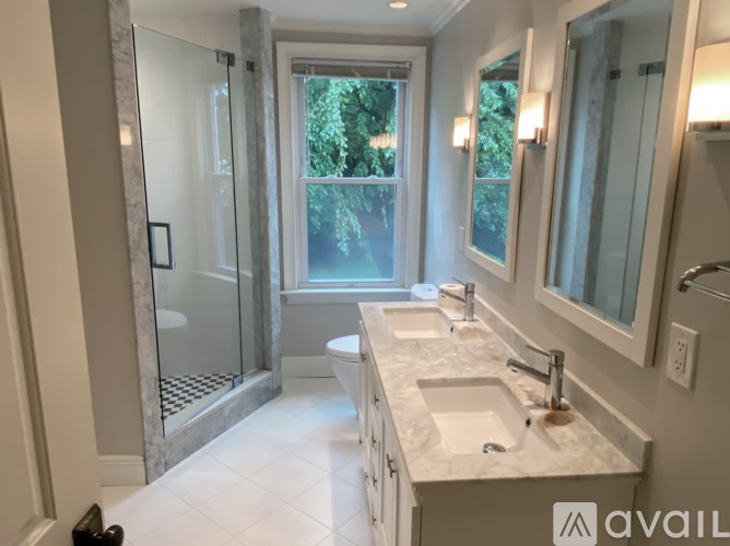 A bathroom with a marble countertop and a walk-in shower.