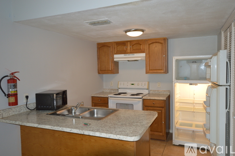 A kitchen with a sink, stove, and refrigerator.