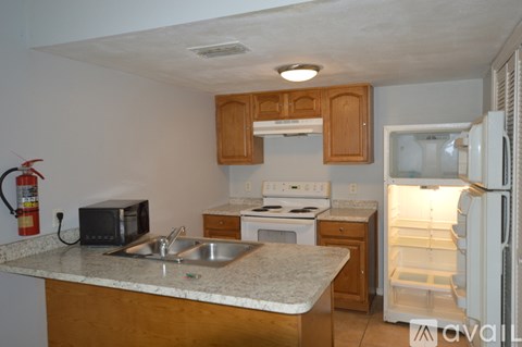 A kitchen with a sink, stove, and refrigerator.