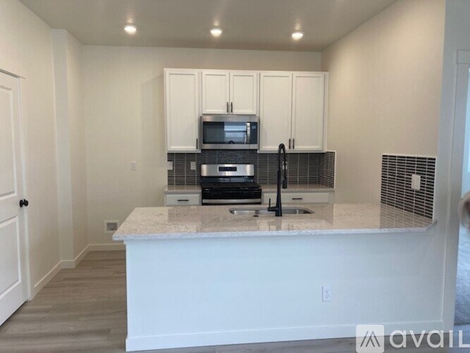 A kitchen with a white countertop and cabinets.