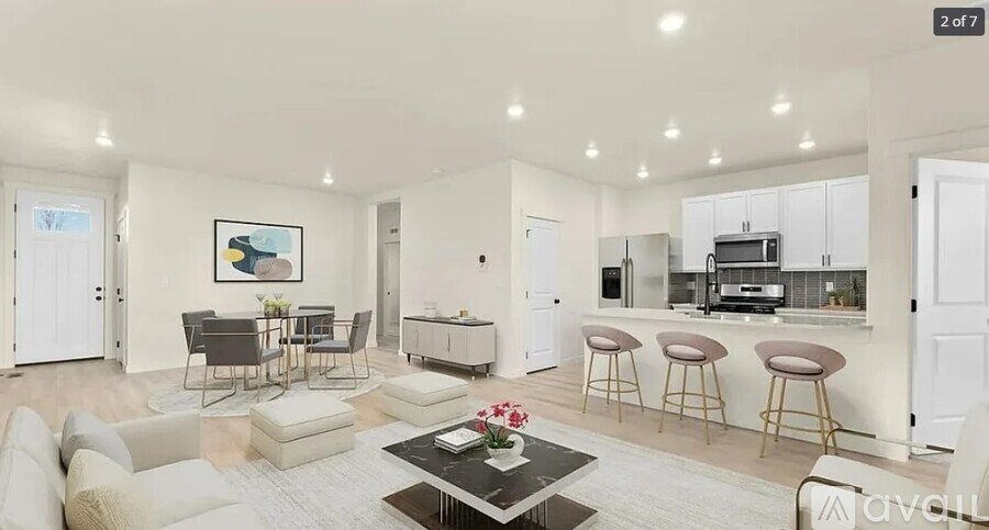 A modern living room with a dining area and kitchen in the background.