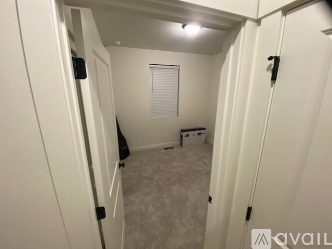 A small, empty room with a window and a white door.