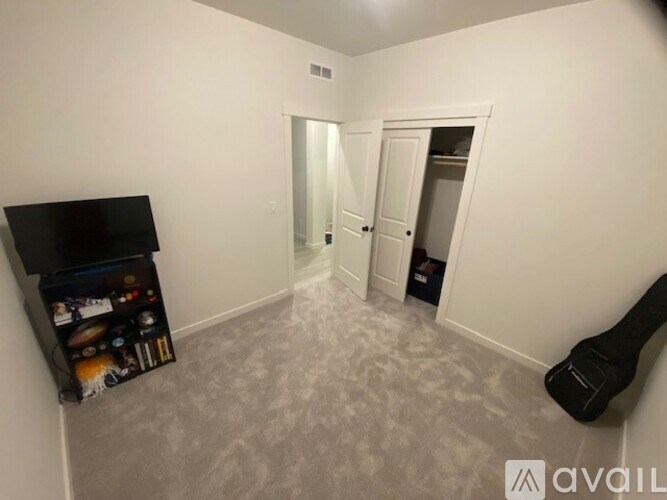 A room with a grey carpet and a blackboard on the wall.