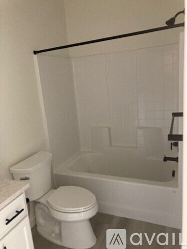 A white toilet sits next to a bathtub in a bathroom.