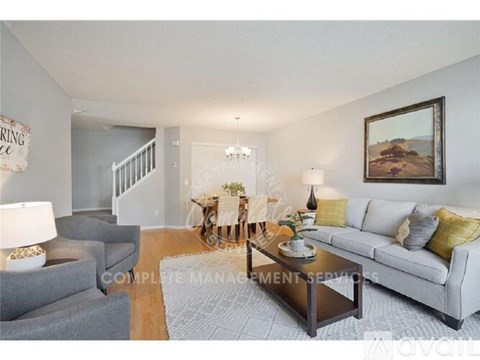 A living room with a grey couch, a coffee table, and a painting on the wall.