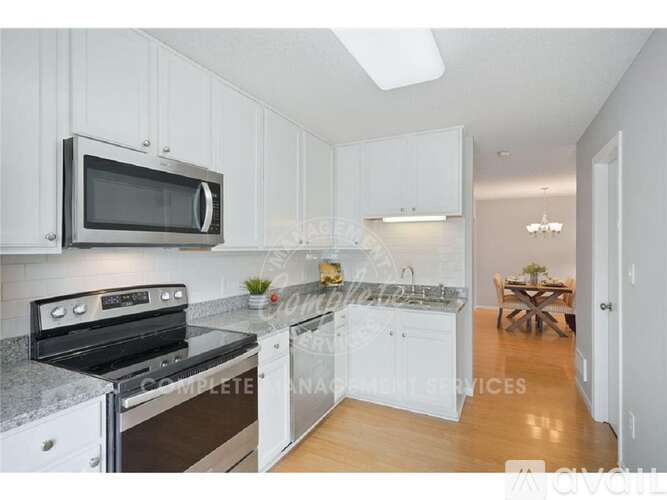 A kitchen with white cabinets and a black stove top oven.