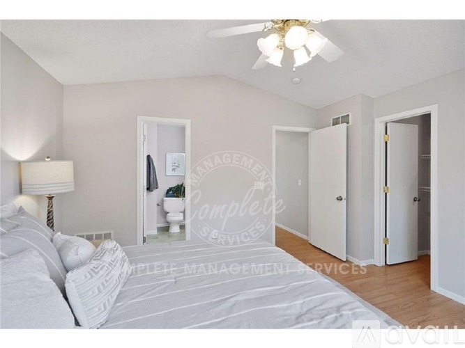 A bedroom with a large bed and a ceiling fan.