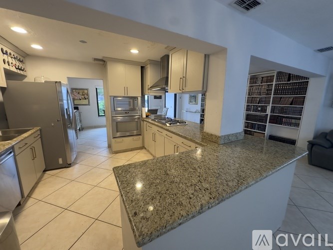 A kitchen with granite countertops and stainless steel appliances.