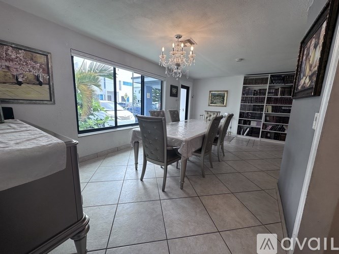 A bedroom with a large bed and a dining area with chairs and a table.