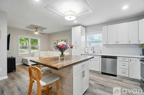 A kitchen with a wooden table and a vase of flowers on it.