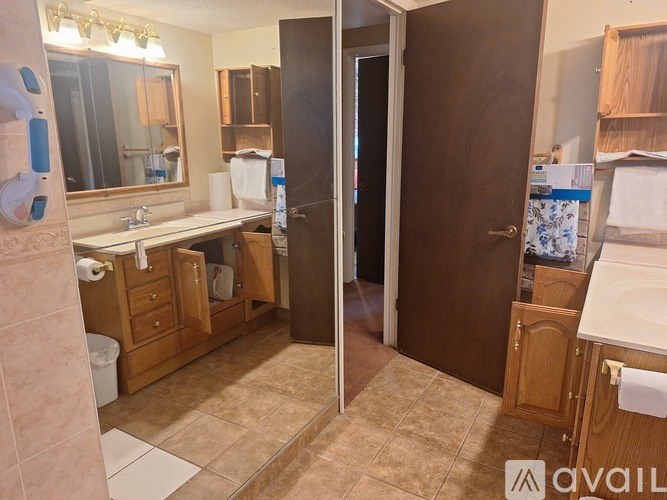 A bathroom with a sink, mirror, and toiletries.