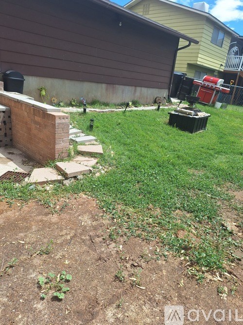 A backyard with a dirt area and a green lawn.