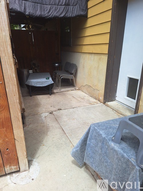 A patio with a grey tarp and a grey plastic chair.