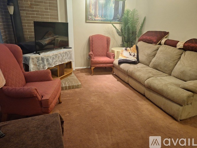 A living room with a fireplace, two chairs, a sofa, and a coffee table.
