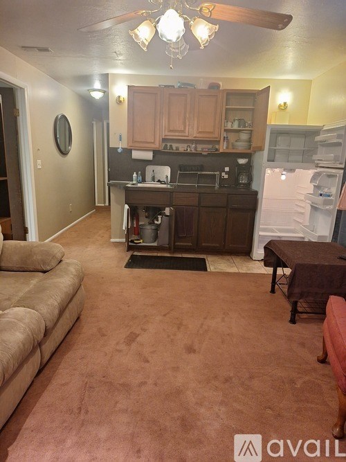A kitchen with a refrigerator, stove, and cabinets.