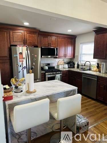 A kitchen with wooden cabinets and a marble table.