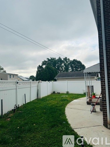 A white fence runs along the side of a house.