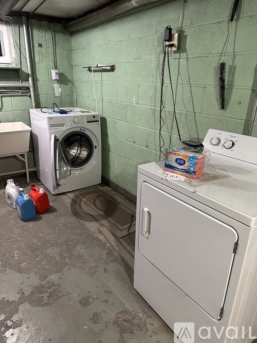 A dirty laundry room with a washing machine, dryer, and a dishwasher.