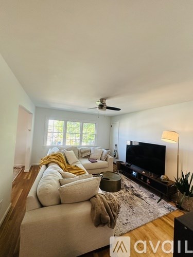 A living room with a white couch and a television.
