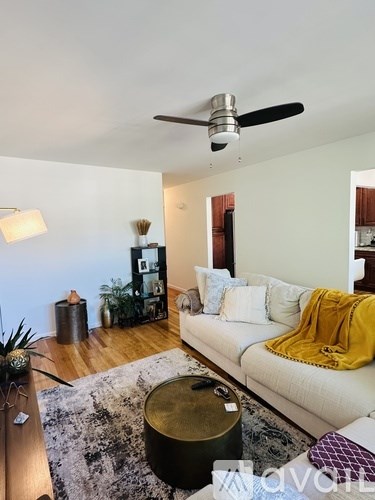 A living room with a white couch and a ceiling fan.