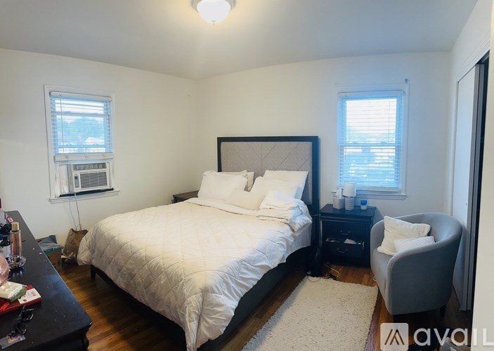 A bedroom with a bed, nightstand, and chair.