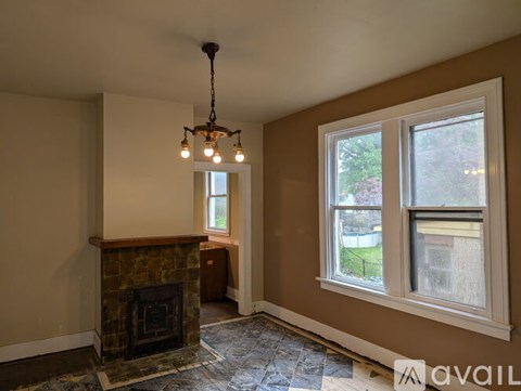 A living room with a fireplace and a window.