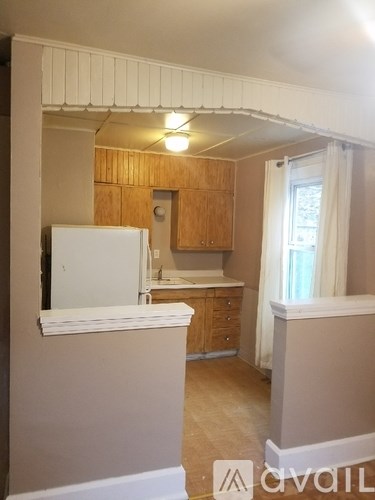 A kitchen with wooden cabinets and a white refrigerator.