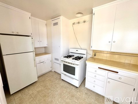A kitchen with white appliances and cabinets.