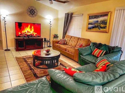 A living room with a fireplace and a painting on the wall.