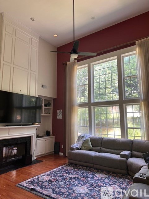 A living room with a grey couch and a fireplace.