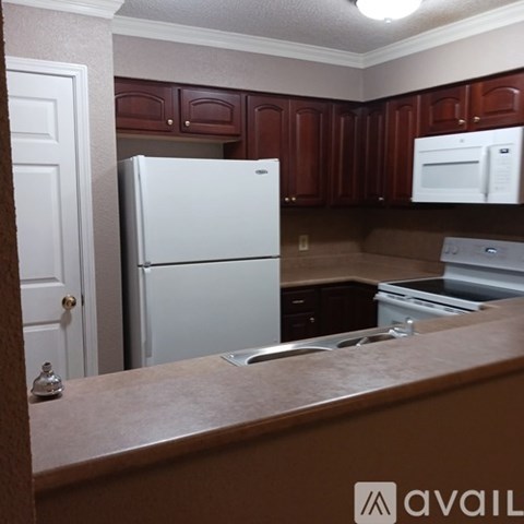 A kitchen with brown cabinets and a white refrigerator.