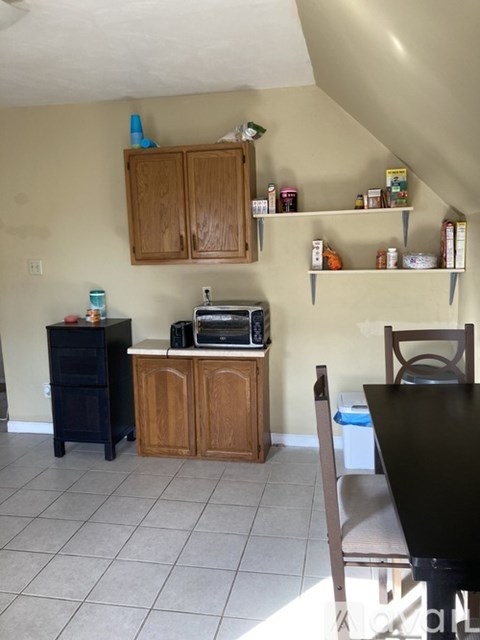 A kitchen with a black table and wooden cabinets.
