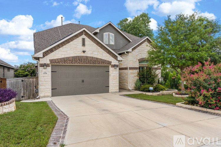 A house with a garage and a driveway in front of it.
