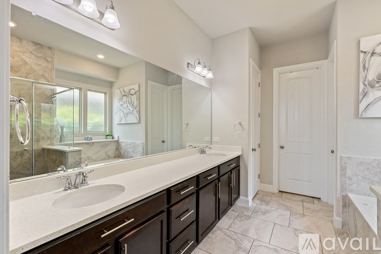 A bathroom with a large mirror, sink, and vanity.