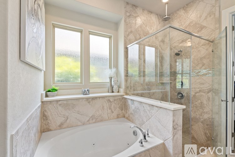 A modern bathroom with a large tub and a glass shower.
