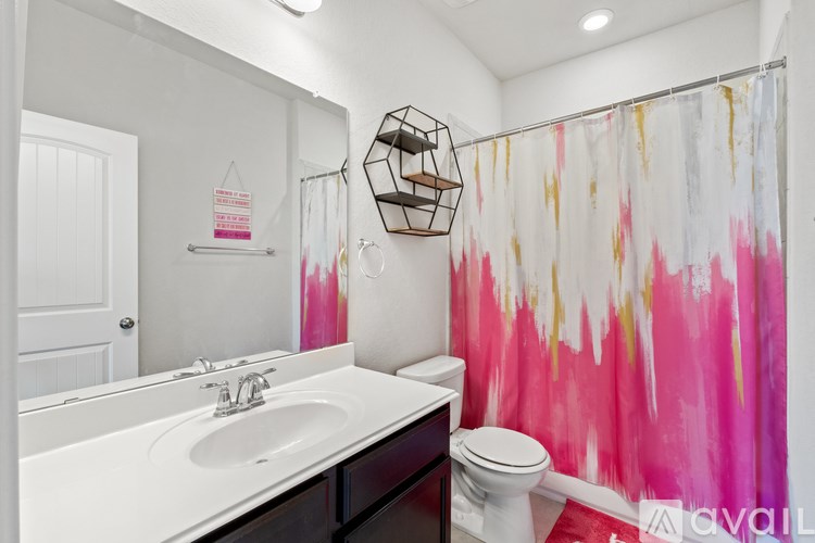 A bathroom with a pink and white shower curtain.