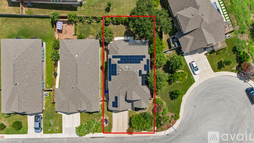 A bird's eye view of a neighborhood with a red square highlighting a house with solar panels.
