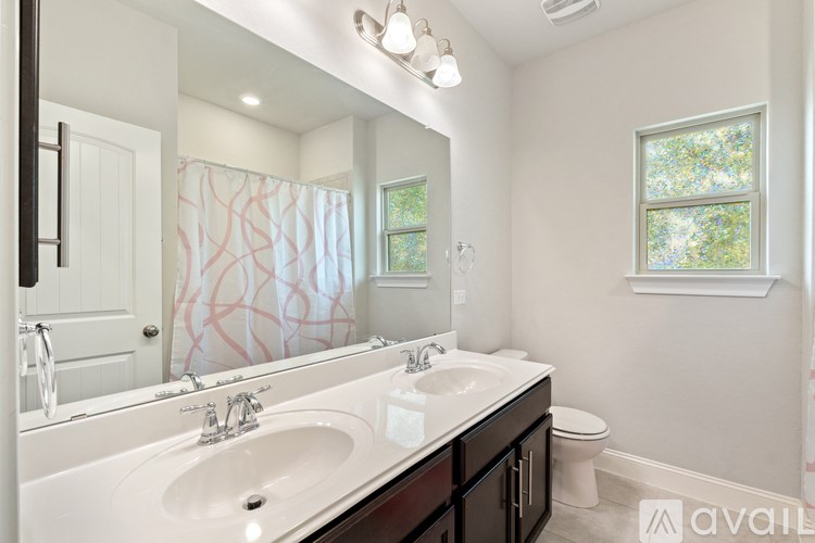 A bathroom with a white sink and a window.