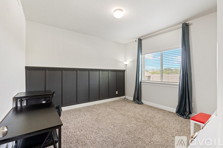 A room with a black piano and a grey carpet.
