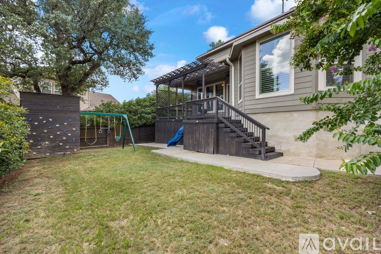A house with a deck and a swing set in the backyard.