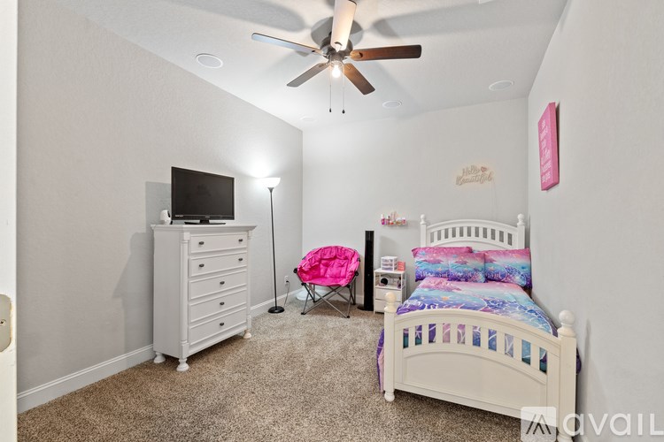 A bedroom with a bed, dresser, and television.