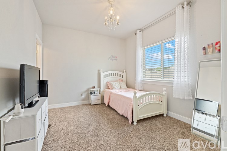 A bedroom with a bed, dresser, and television.