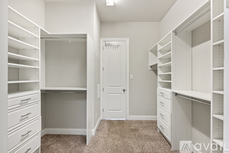 A white walk-in closet with drawers and shelves.