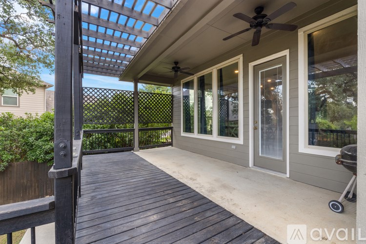 A patio with a ceiling fan and sliding glass doors.