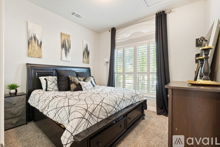 A bedroom with a large bed and a wooden dresser.