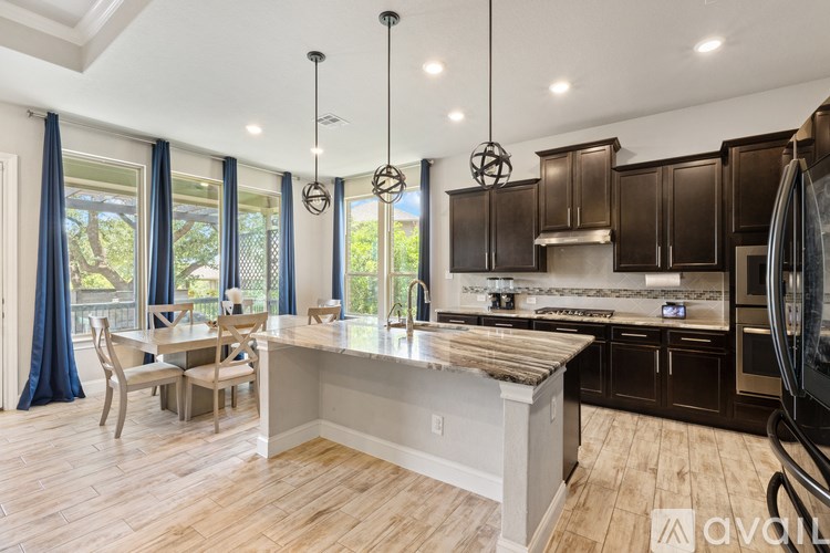 A kitchen with wooden floors and a large island in the middle.